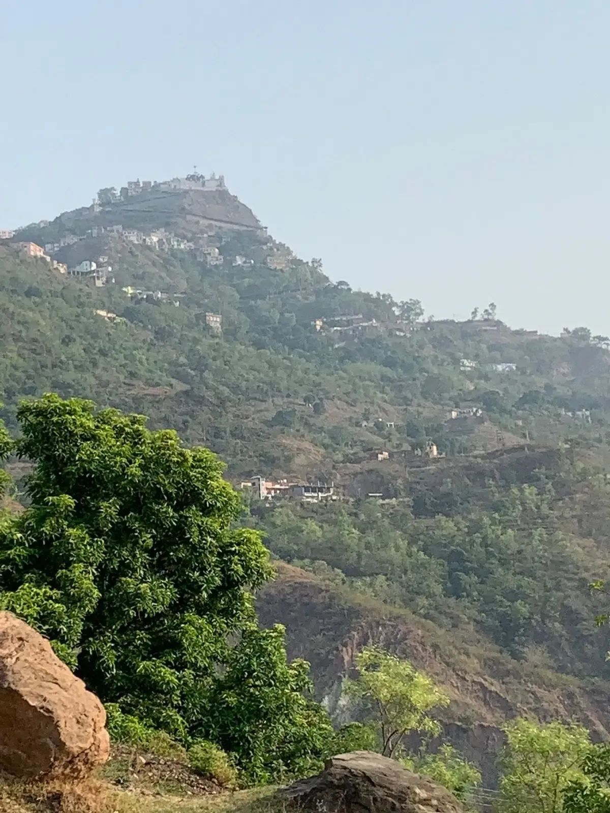 The temple town of Naina Devi strung along its hilltop, seen from the road on the far side of the valley.